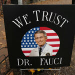Fauci’s Top Expert REFUSED Vaccine — Terrifying Reason… Sign reading We Trust Dr. Fauci on display.