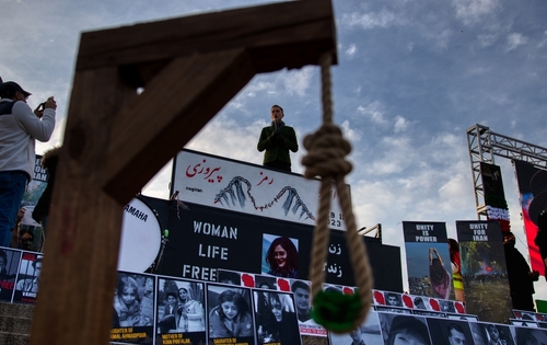 shutterstock_2261148885.jpg A protest scene with a speaker and a noose symbolizing oppression