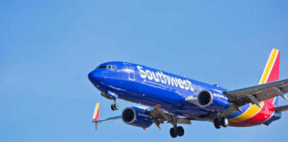 Jet aircraft in flight against clear blue sky.