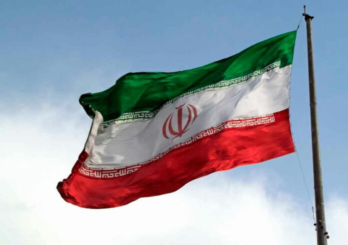 1088416085 Iranian flag flying against a clear sky.