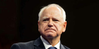 Man in suit with American flag pin.