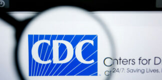Magnifying glass over CDC logo on a website.