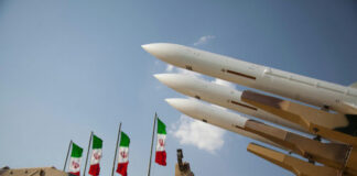Military missiles displayed with Iranian flags in the background