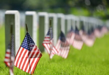 Radioactive Grave SECRETS Exposed at Arlington… American flags beside gravestones in a cemetery.