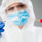 SHOCKING Ebola Surge—Are U.S. Borders Safe? Healthcare worker holding a COVID-19 test kit and swab