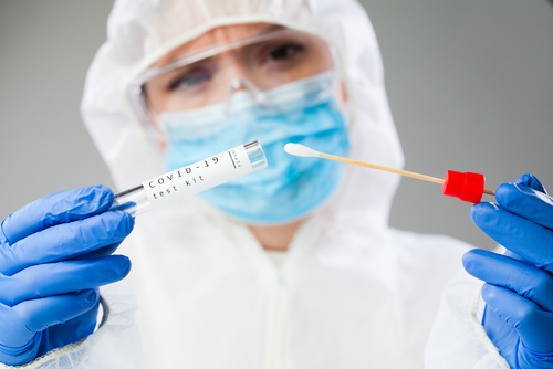 Medical,Healthcare,Nhs,Technician,Holding,Covid-19,Swab,Collection,Kit,wearing,White Healthcare worker holding a COVID-19 test kit and swab