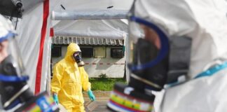 Emergency responders in hazmat suits preparing for a situation