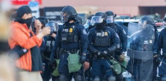 Police officers in riot gear standing in formation during a protest