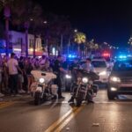 Norfolk STREETS in Turmoil: Who’s Behind It? Police officers managing a crowd on a busy street at night