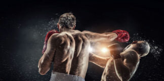 Boxer punches opponent during intense boxing match.
