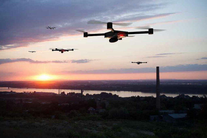 1143966755-2 Drones flying over a landscape at sunset.