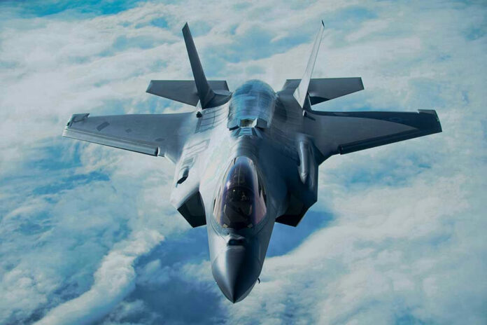 Stealth fighter jet flying above the clouds.
