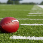 QB’s $90K Bets Ignite Legal War Football resting on a grassy field.