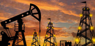 Oil rigs silhouetted against a sunset sky.