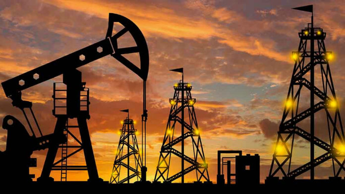 Oil rigs silhouetted against a sunset sky.