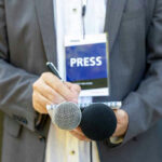 Violent Remark Claims Ignite D.C. Firestorm Press member holding microphones and taking notes.