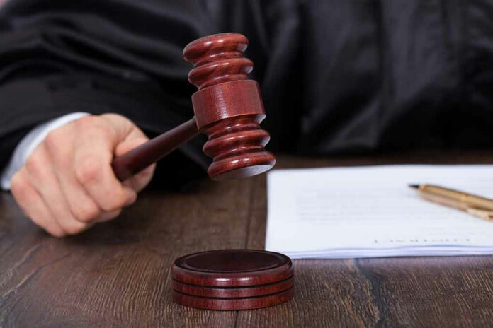 186812807 Judge striking gavel near documents and pen.