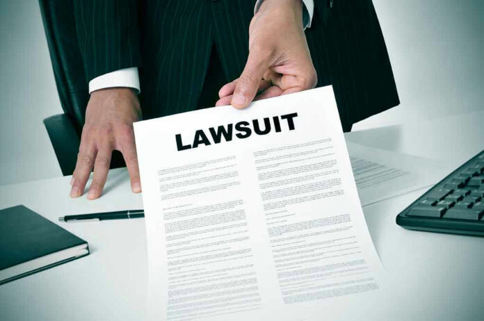 Holding a document titled Lawsuit in an office.