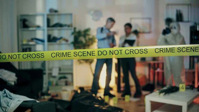 2386626691 Crime scene tape in front of investigators and forensic unit.