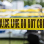 Hot Grease, Knife—Who Struck First? Yellow police tape that says, Police Line Do Not Cross.