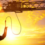 Person bungee jumping against a sunset backdrop