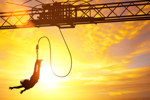 Silhouette,Of,Women,Jumping,Down,Bungee,Jump,Sport,In,Sunset Person bungee jumping against a sunset backdrop
