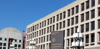 United States Department of Labor building exterior with sign and flags