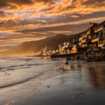 Coastal view at sunset with homes along the shore