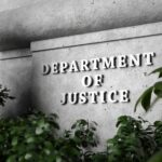 Sign for the Department of Justice surrounded by greenery