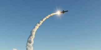 Missile launching into the sky with smoke trail.