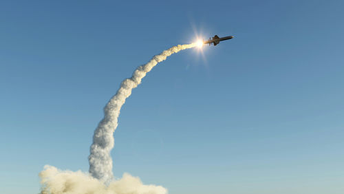 shutterstock_539376745 Missile launching into the sky with smoke trail.