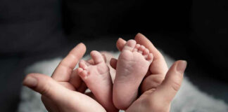 Hands holding newborn babys feet.