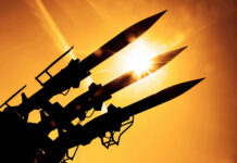 Missiles Over Kuwait — Who’s Really Behind It? Silhouetted missiles on a launcher against a bright sunset sky
