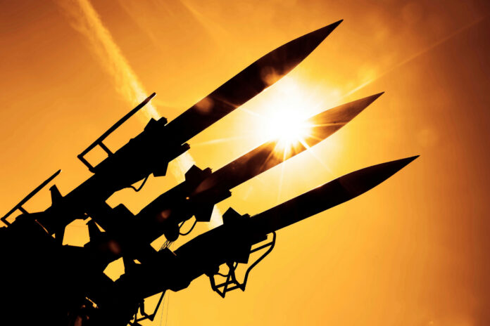 shutterstock2027733749jpg Silhouetted missiles on a launcher against a bright sunset sky