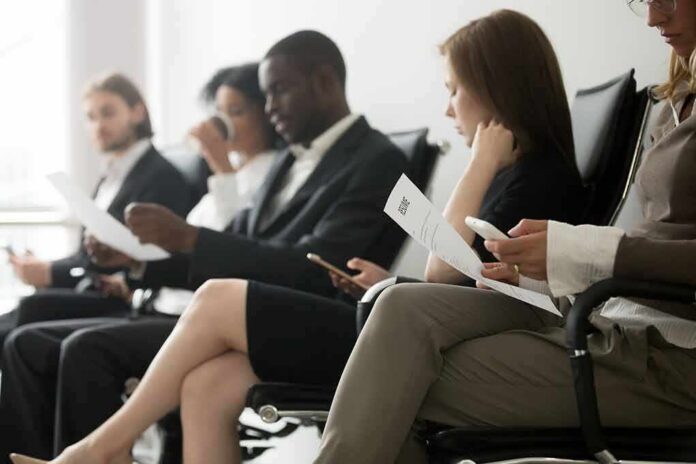 Job applicants seated in a waiting area reviewing documents