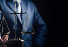 Scales of justice held by a person in a suit