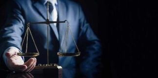 Scales of justice held by a person in a suit