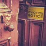 Outrage in Baltimore: Pay-To-Get Home Back Weathered wooden door with eviction notice