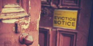 Weathered wooden door with eviction notice