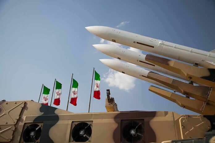 shutterstock_1621002841 Missile launchers on a military vehicle with flags in the background