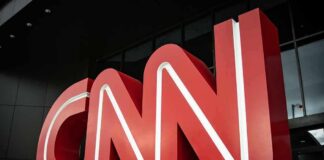 Large red CNN logo outside a modern building entrance