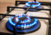 Close-up of two lit gas stove burners.
