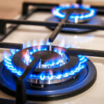 Close-up of two lit gas stove burners.
