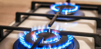 Close-up of two lit gas stove burners.