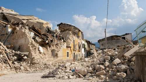 shutterstock_2259963673 Rubble from collapsed buildings in earthquake-hit area. Clear sky.