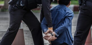 Police officers arresting a suspect in handcuffs
