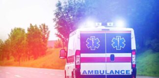Ambulance van with flashing lights on a rural road