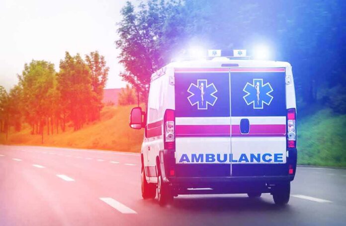 Ambulance van with flashing lights on a rural road