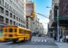 When Smart Infrastructure Starts Watching You City street with yellow school bus passing under traffic light