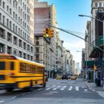 When Smart Infrastructure Starts Watching You City street with yellow school bus passing under traffic light